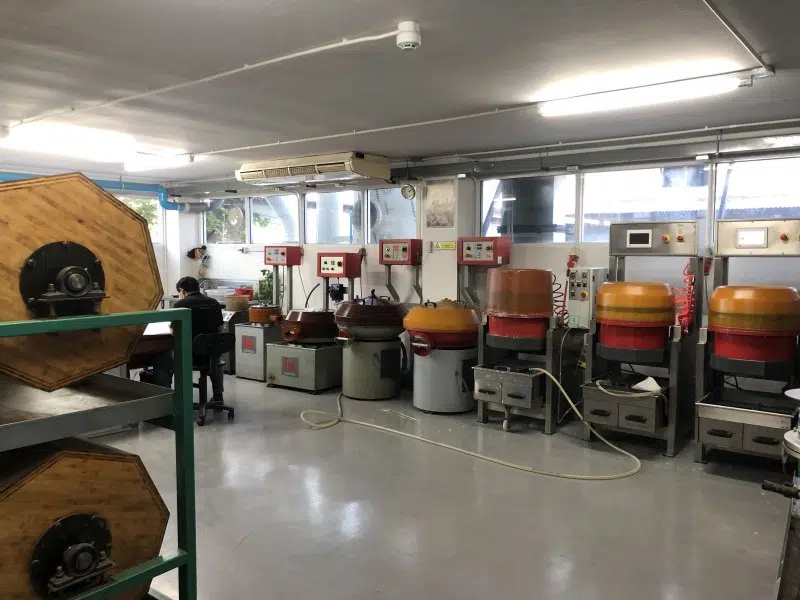 Tumbling machine smoothing and deburring jewelry surfaces