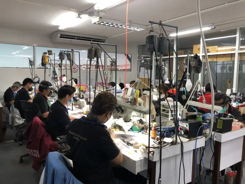 Expert stone setters hand-setting gemstones into jewelry